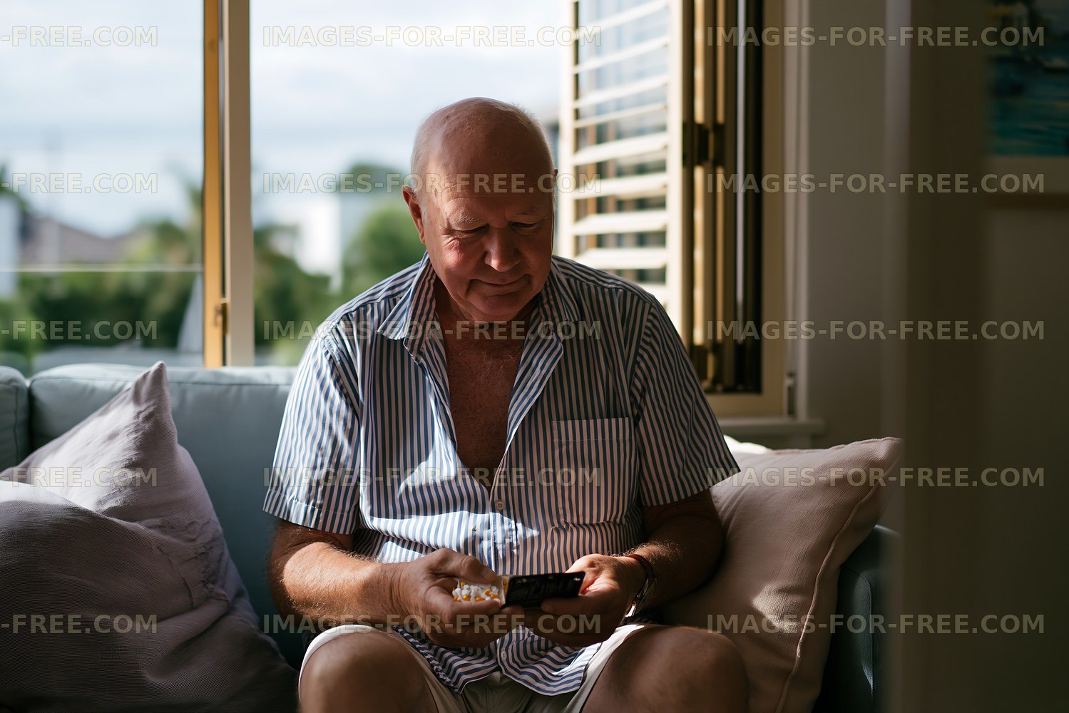 Man sitting on couch using smartphone indoors