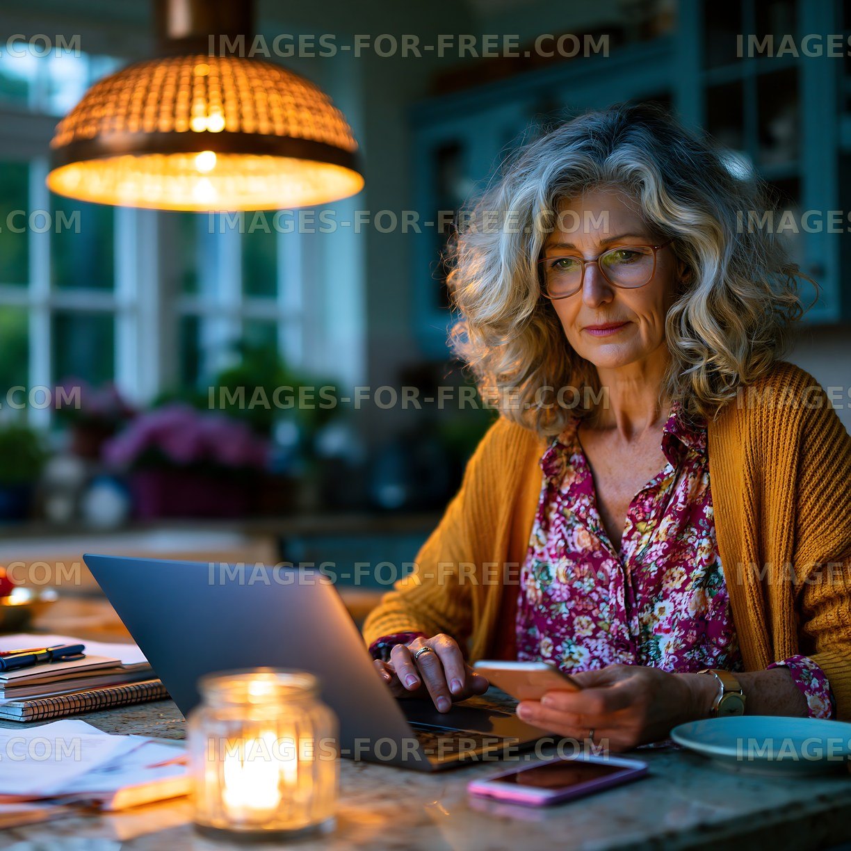 Woman working on a laptop in a cozy kitchen at night