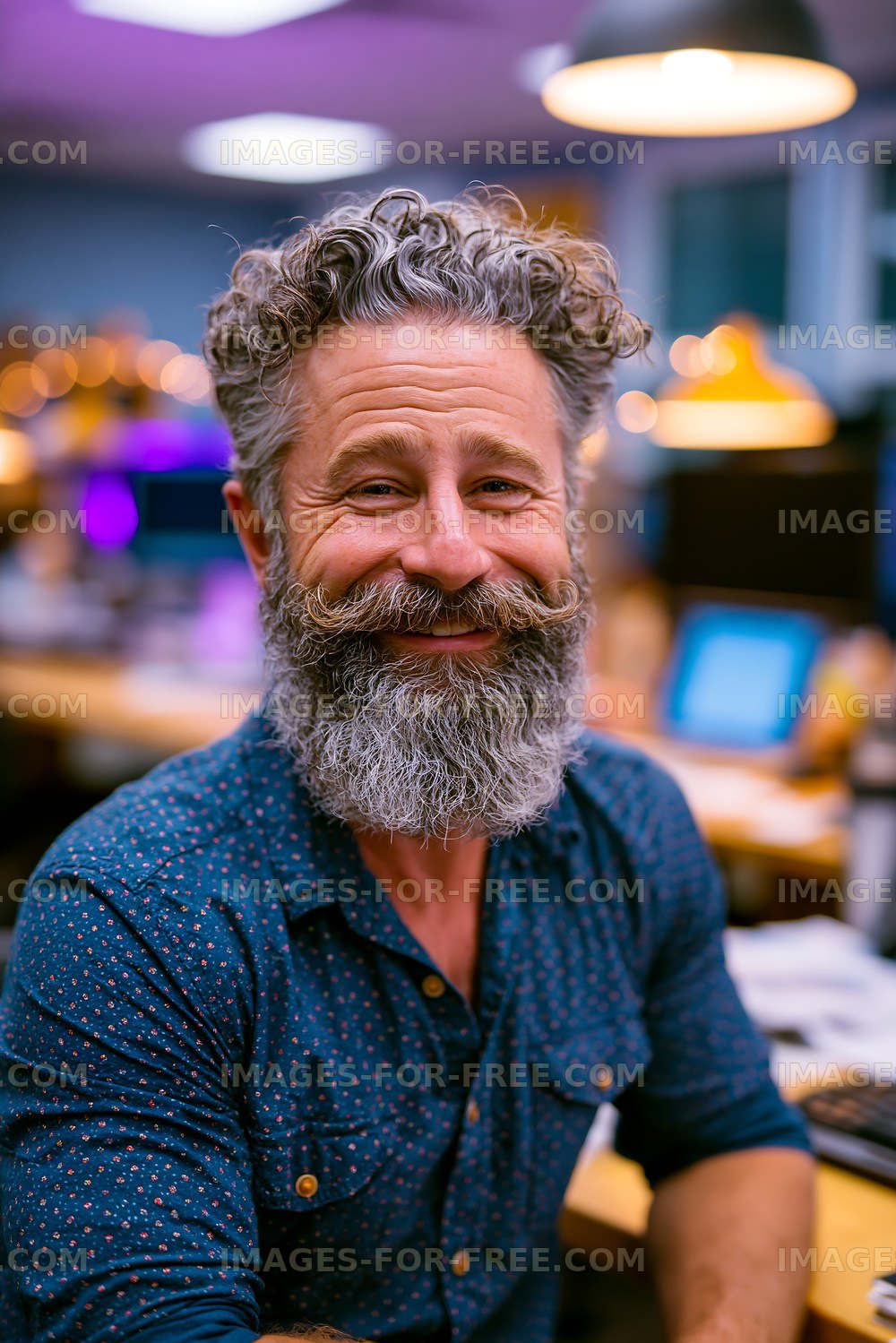 Man with a beard smiles in an office setting