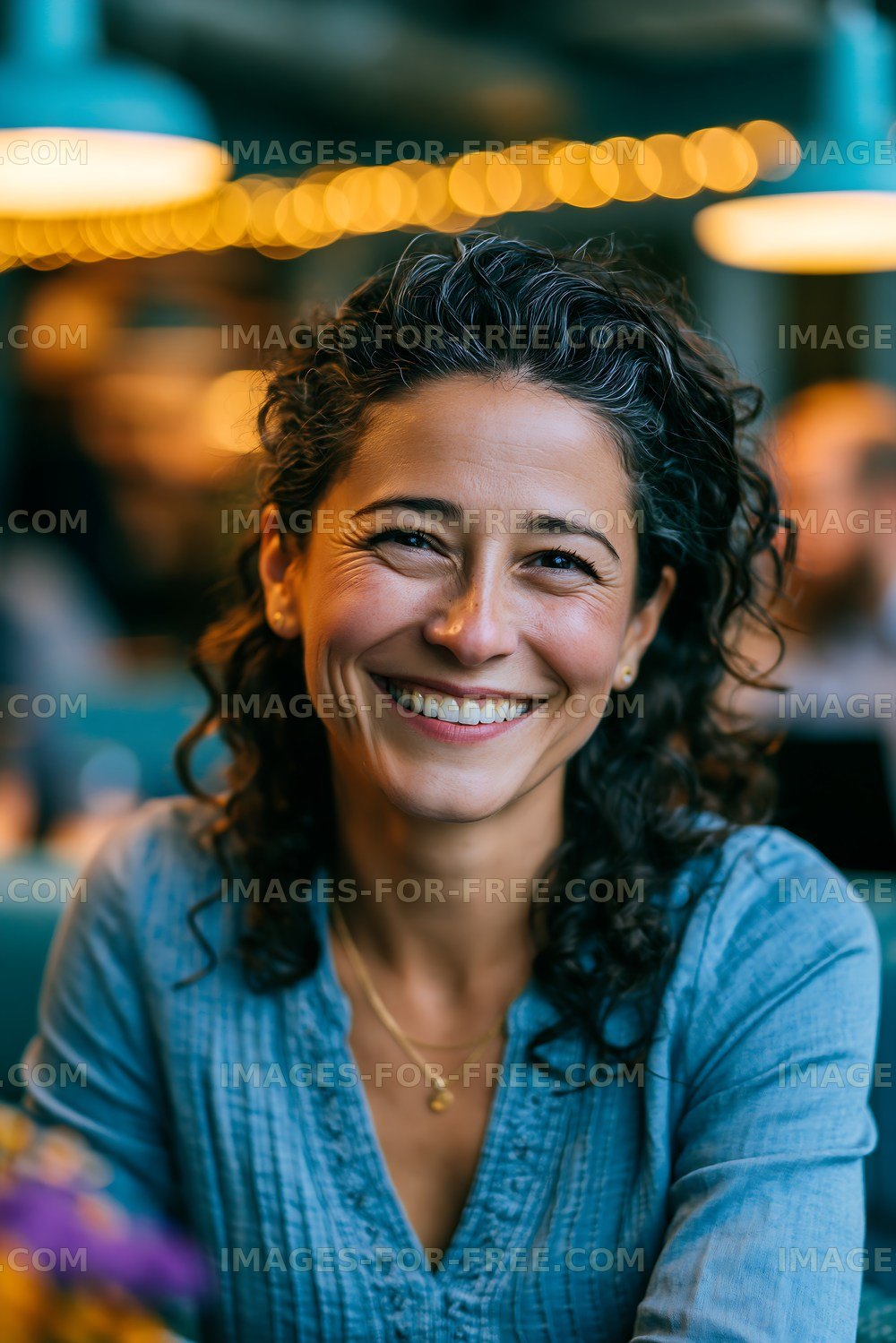 Smiling woman with curly hair sitting in a cafe