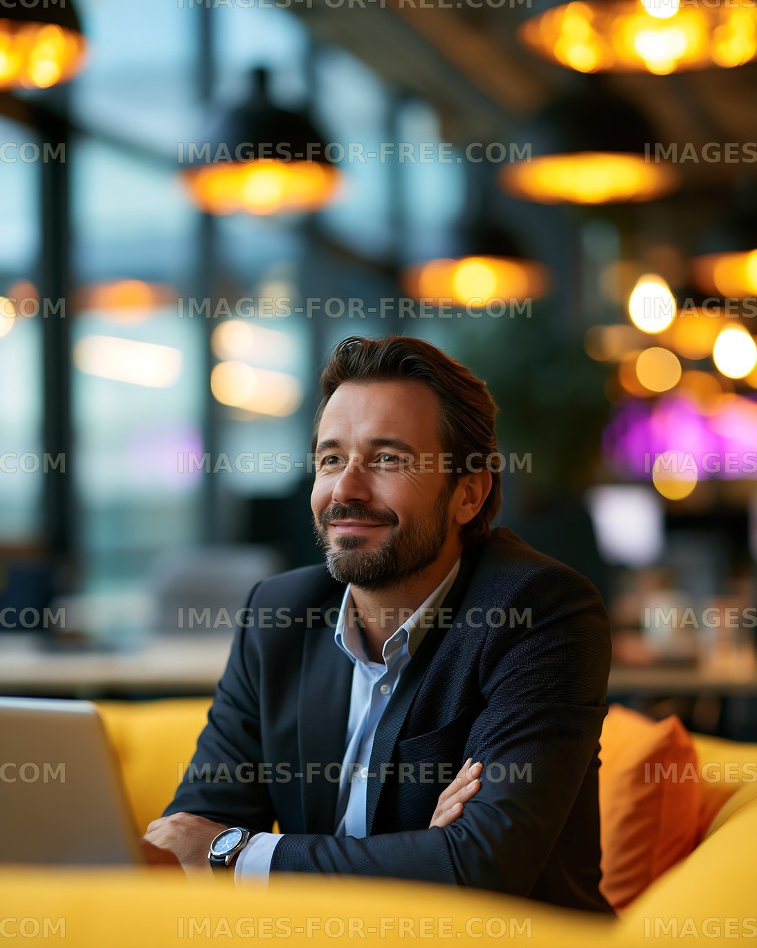 Man sitting in a modern workspace with a laptop and warm lighting