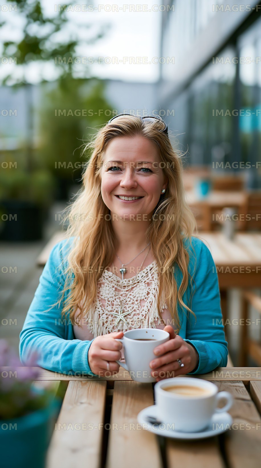 Woman sitting at a cafe table holding a cup of coffee