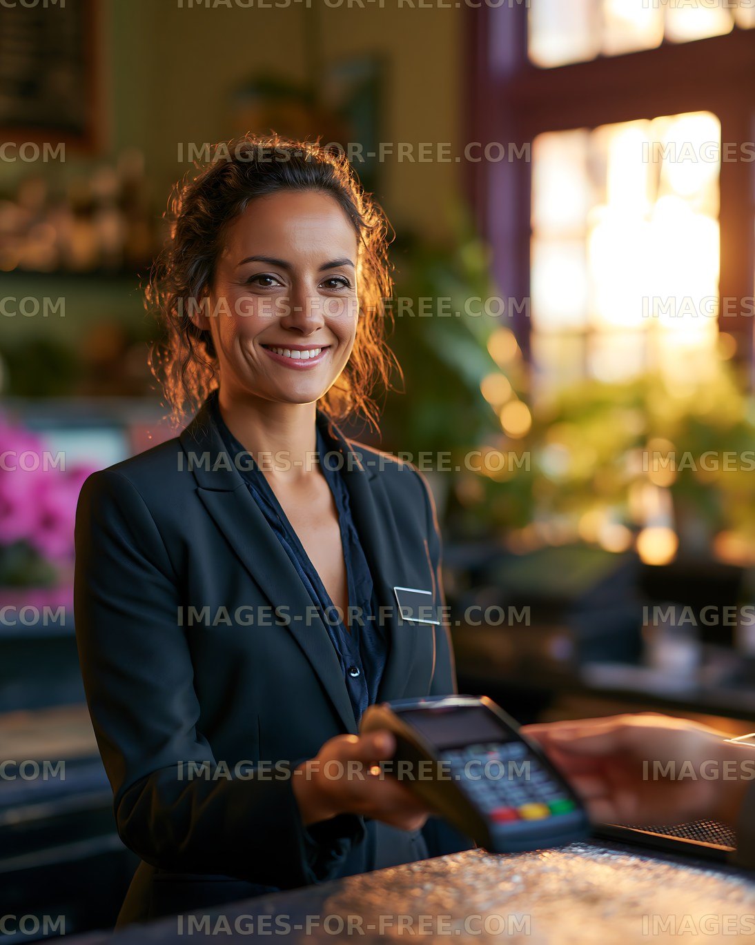 Woman holding a payment terminal in a warm cafe setting