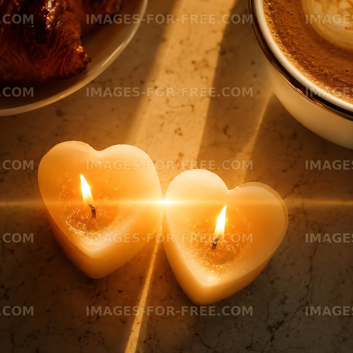 Heart-shaped candles beside coffee and croissant
