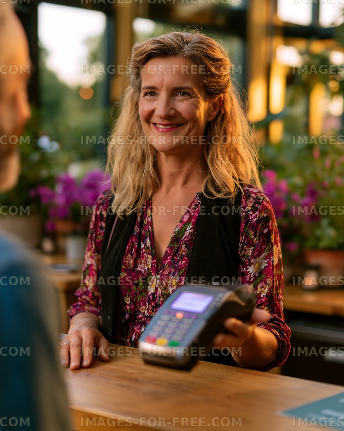 Cashier assisting customer at a cafe during sunset