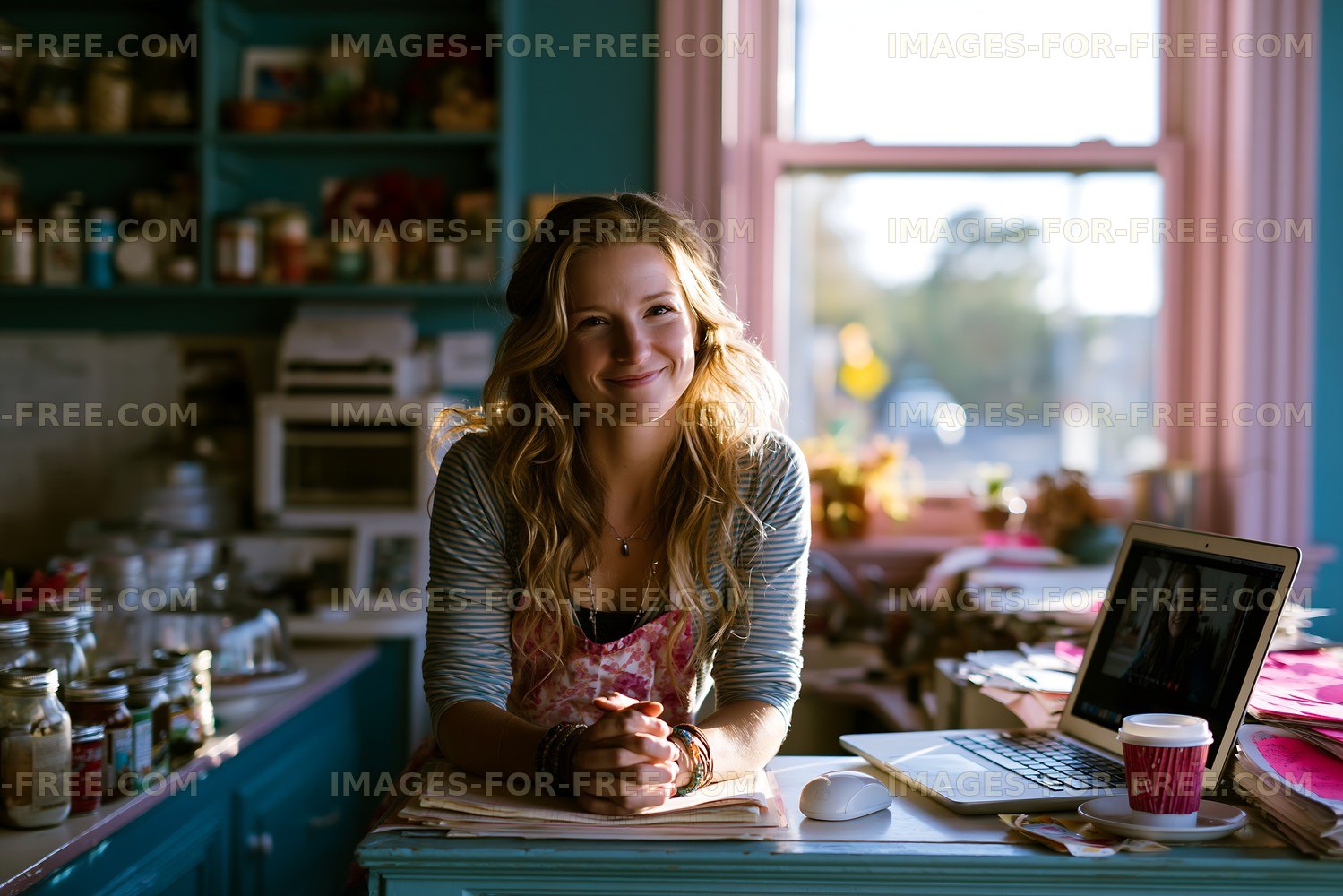 Young woman smiling in a bright kitchen with a laptop