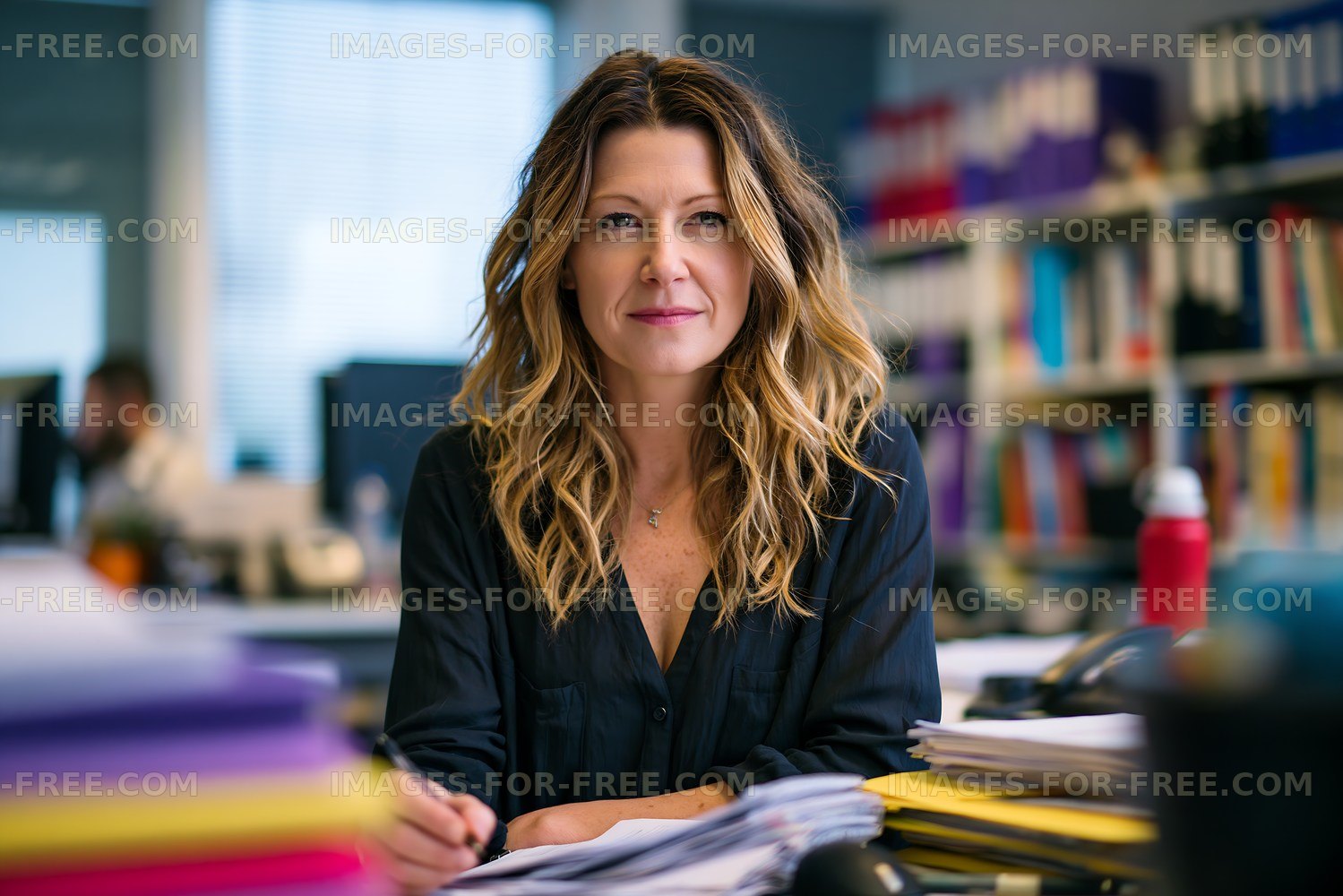 Woman working in an office with papers and documents on desk