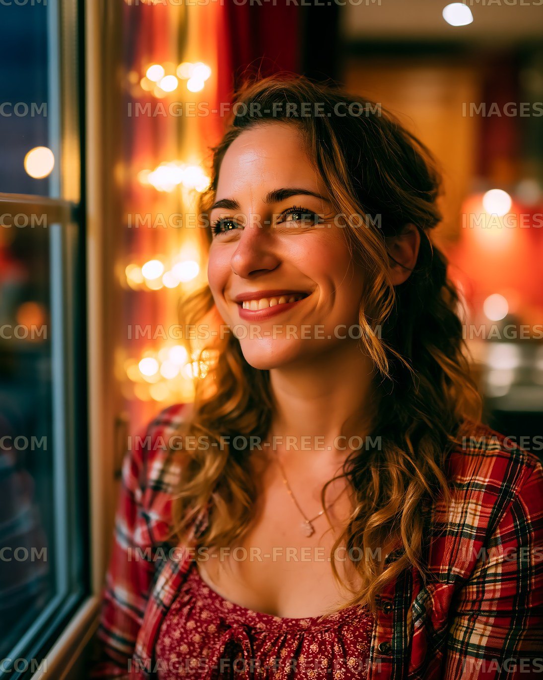 Woman sitting by window with lights in background