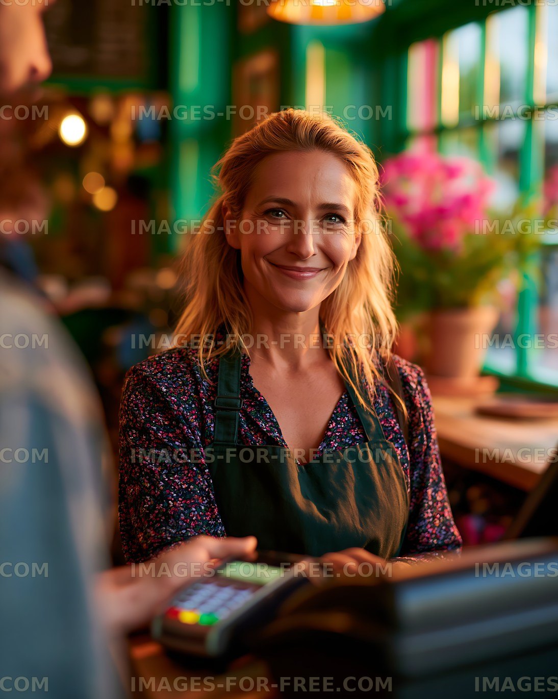 Woman working at a cafe with a customer at the counter