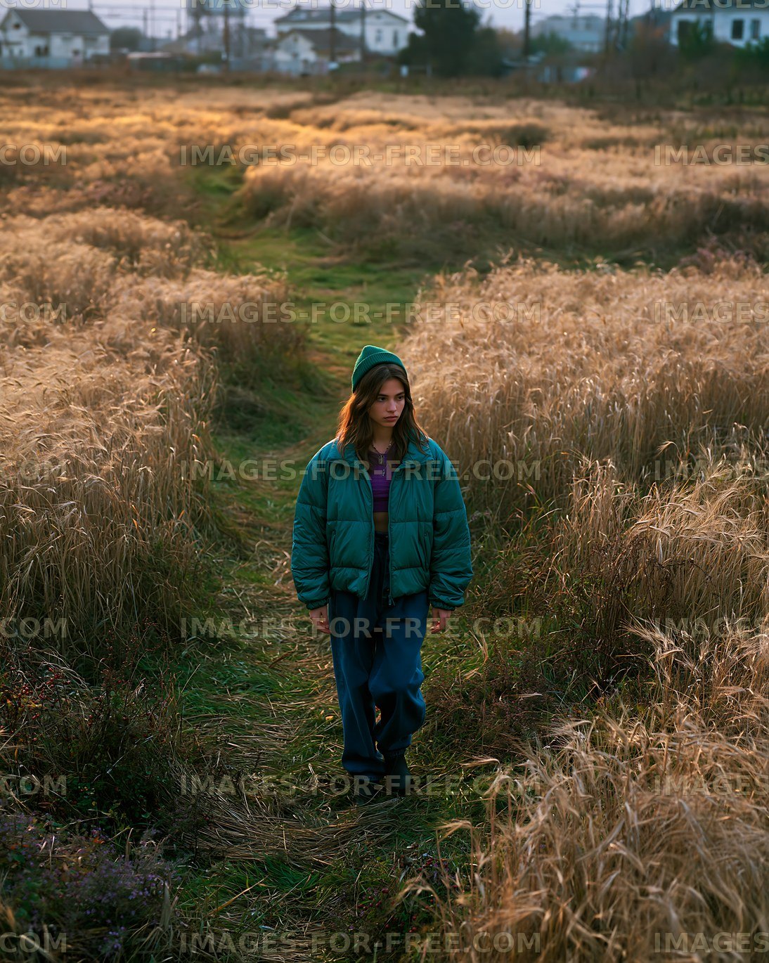 Woman walking on a path through a field during golden hour