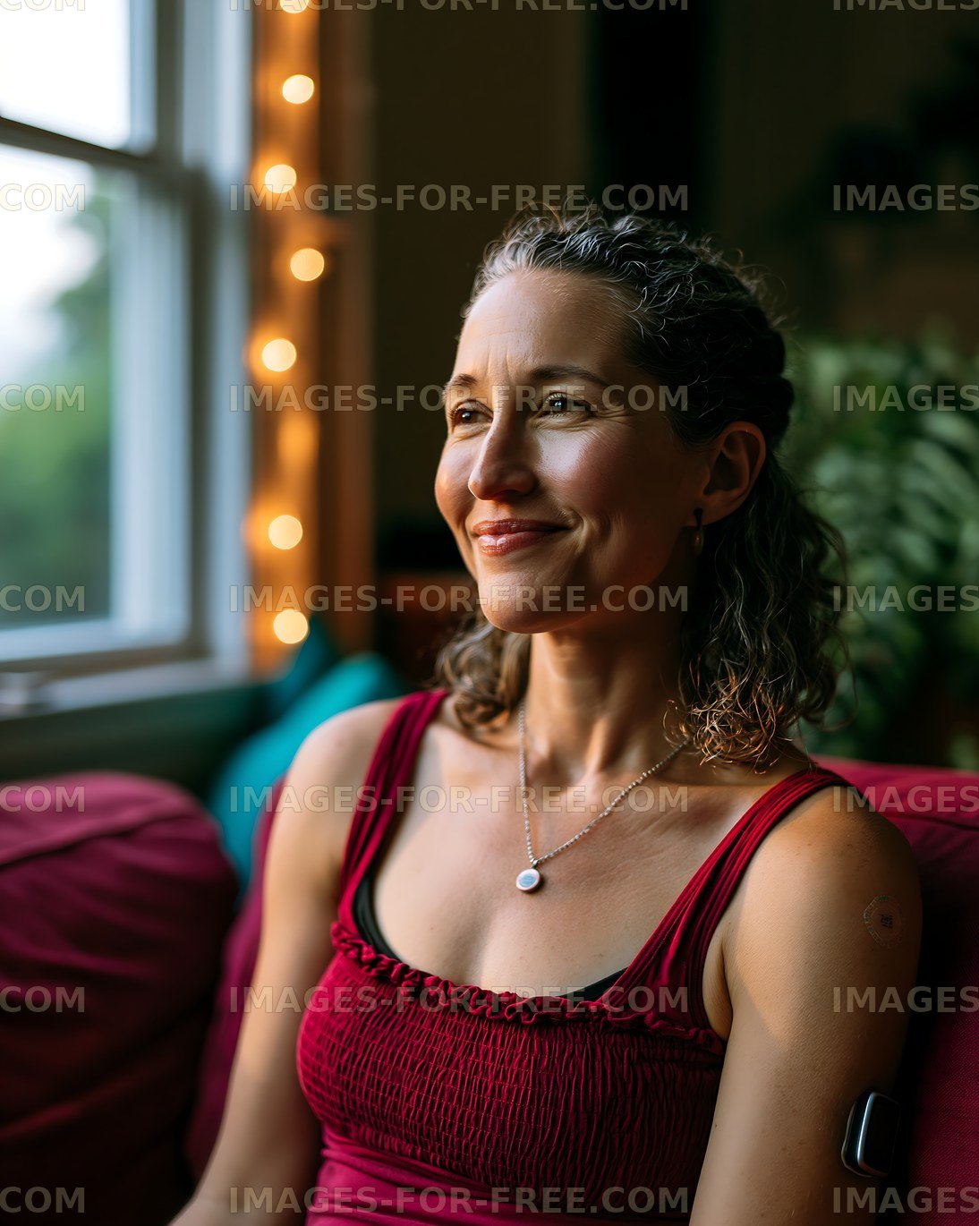 Woman sitting by a window with soft lighting in a cozy room