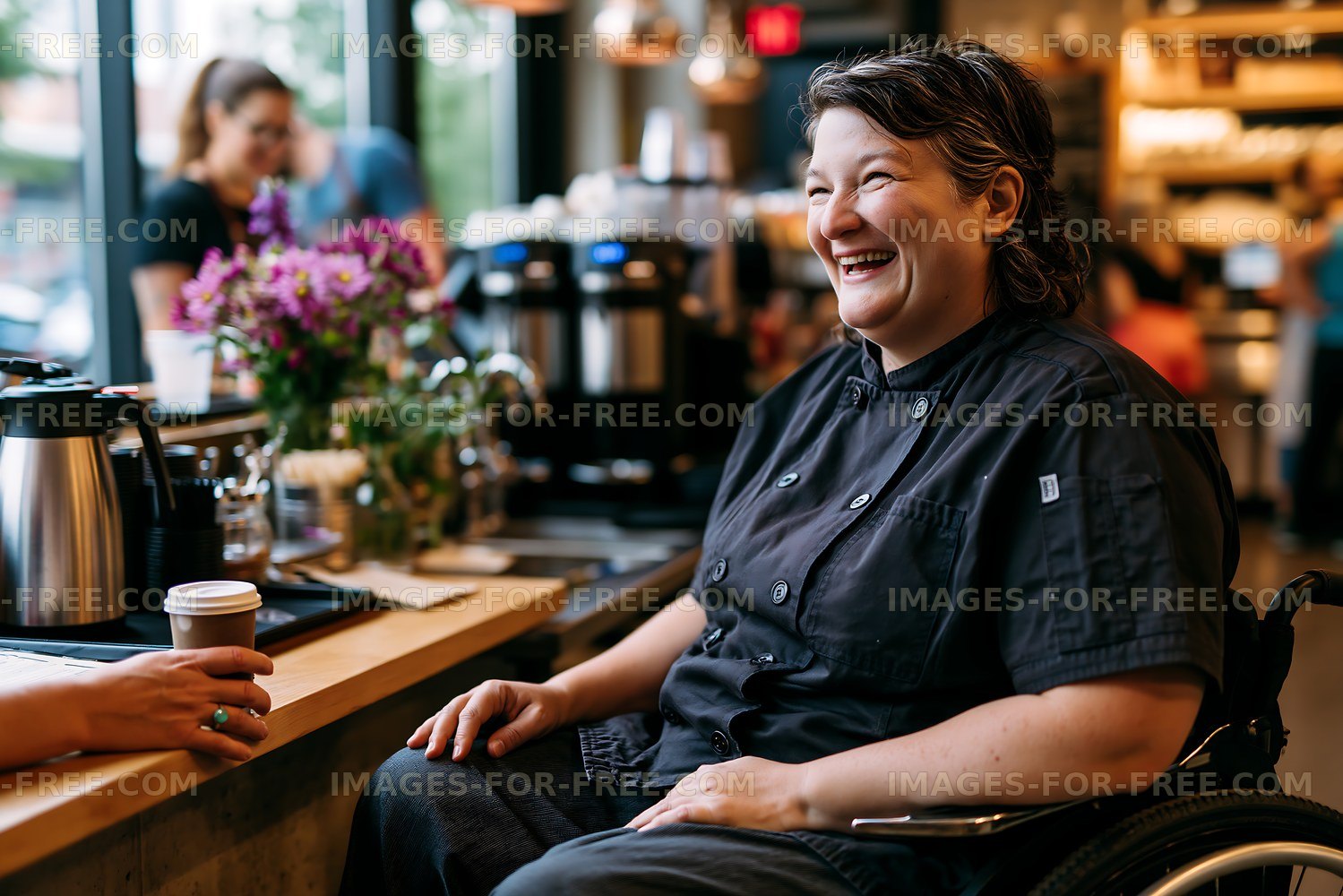 Smiling barista in wheelchair interacting with customers in cafe