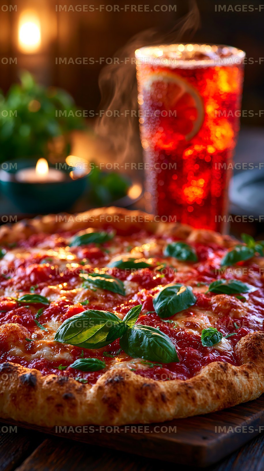Freshly baked pizza with basil and a cold drink on the table