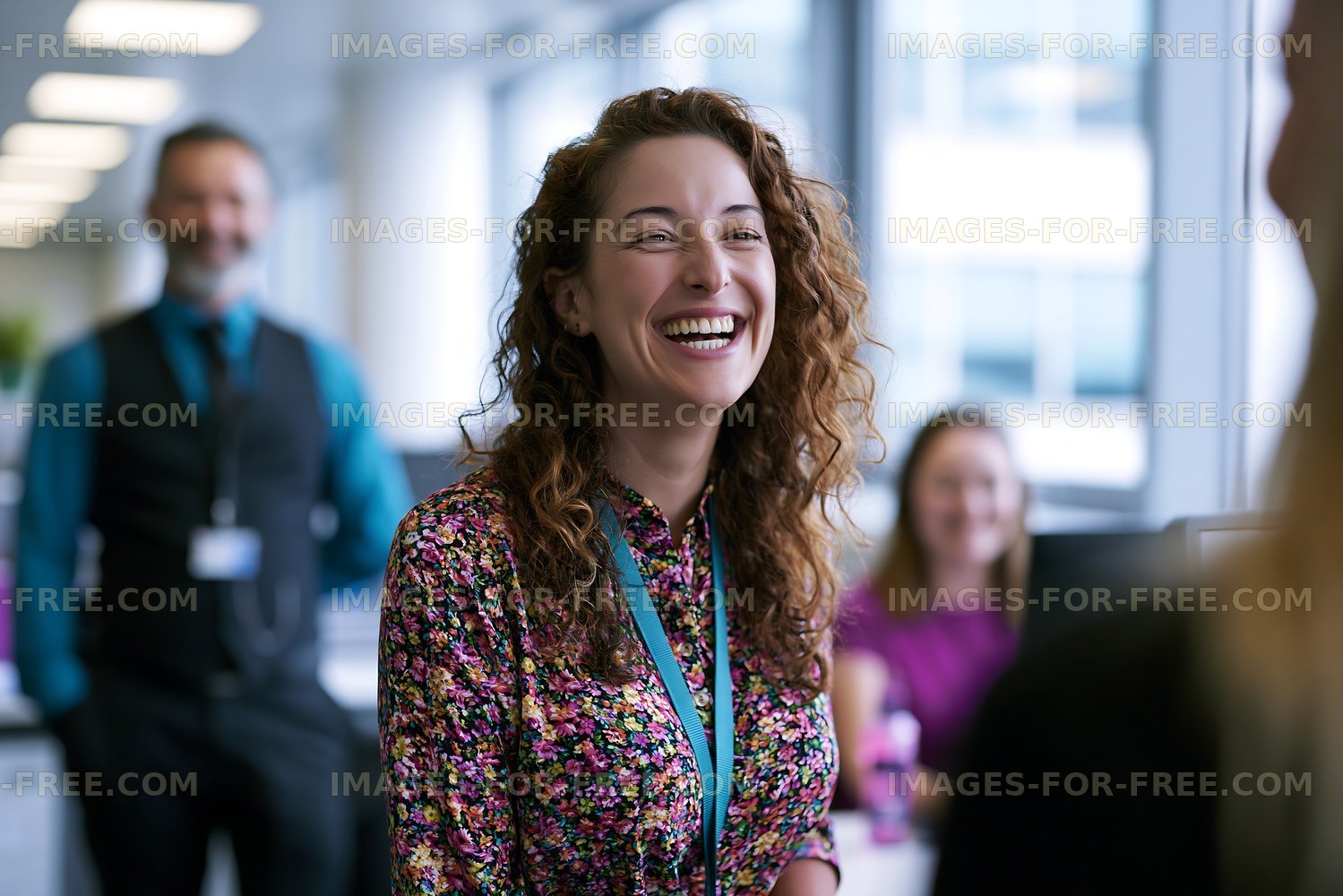 Woman smiling in office during conversation with coworkers