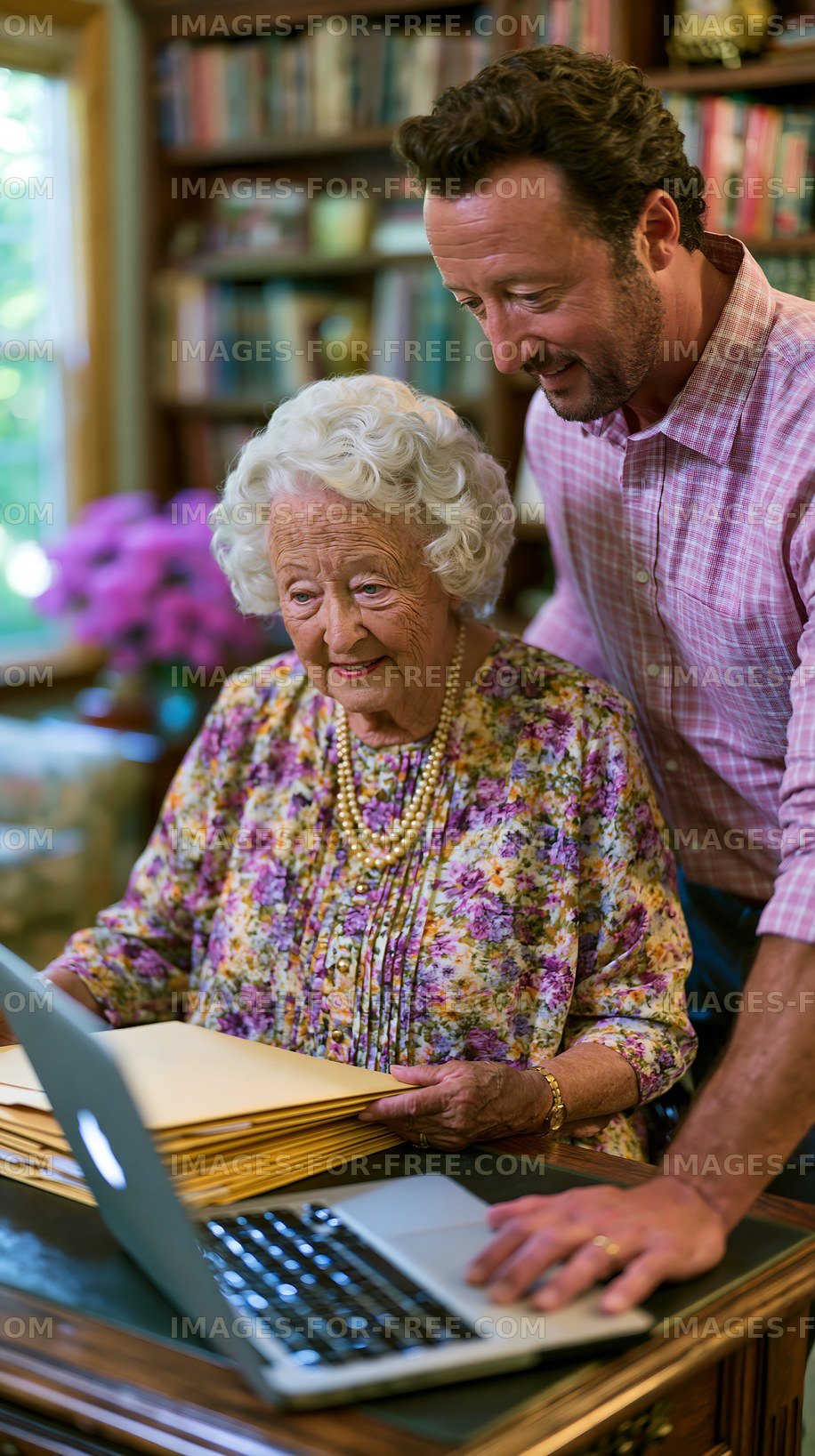 Man helping elderly woman with laptop in cozy home setting