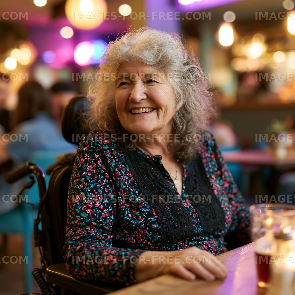 Smiling woman in a wheelchair at a busy cafe
