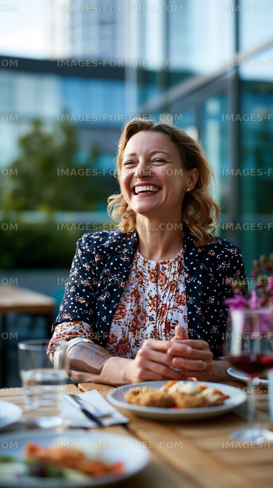 Woman smiling while sitting at a table outdoors in a cafe