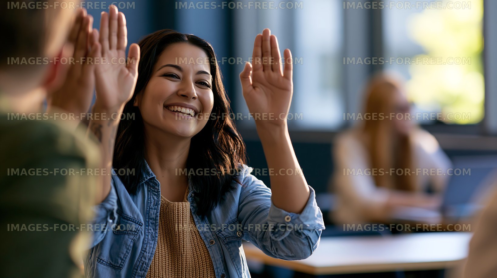 Woman raises hand in classroom during discussion