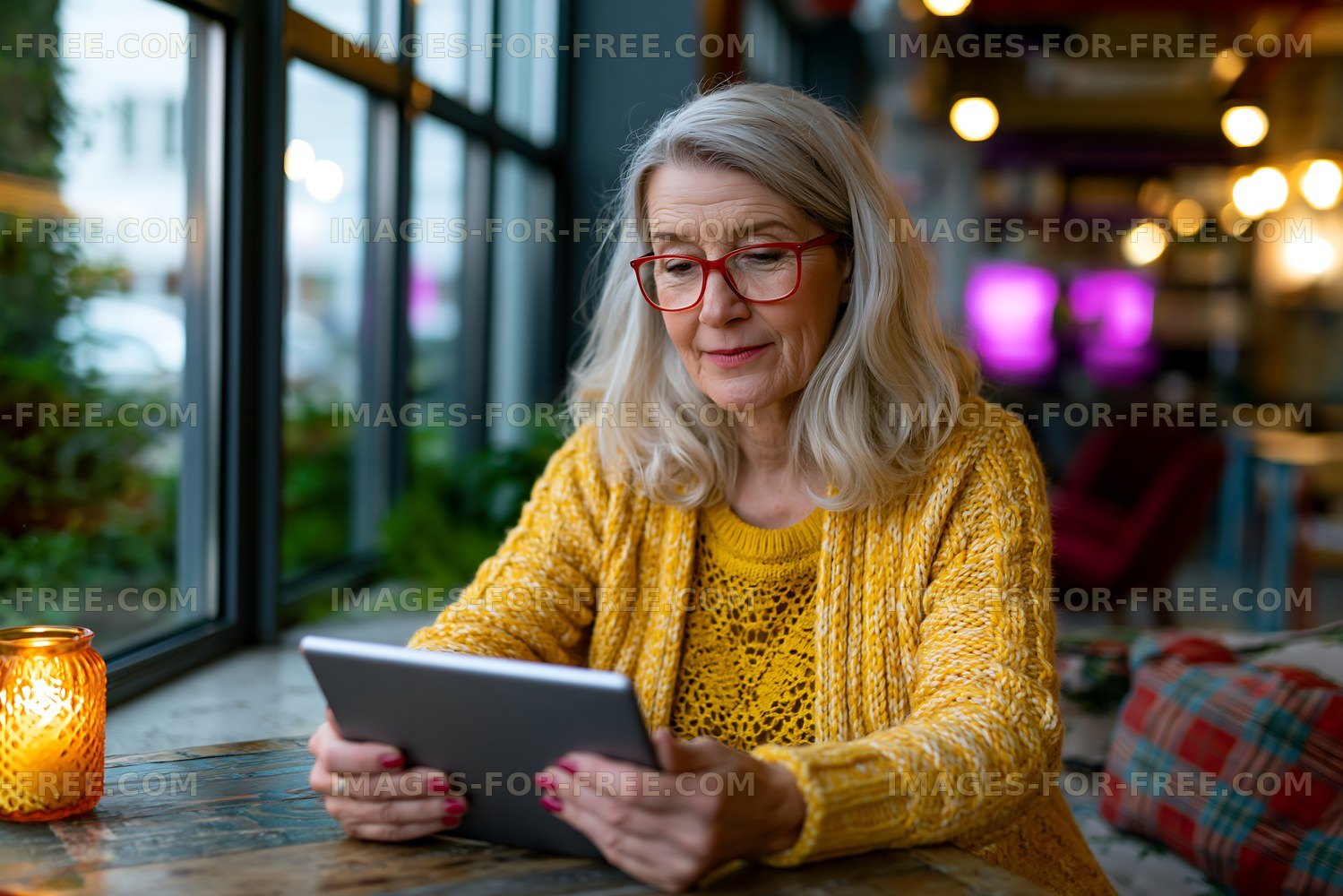 Senior woman using a tablet in a cozy cafe setting