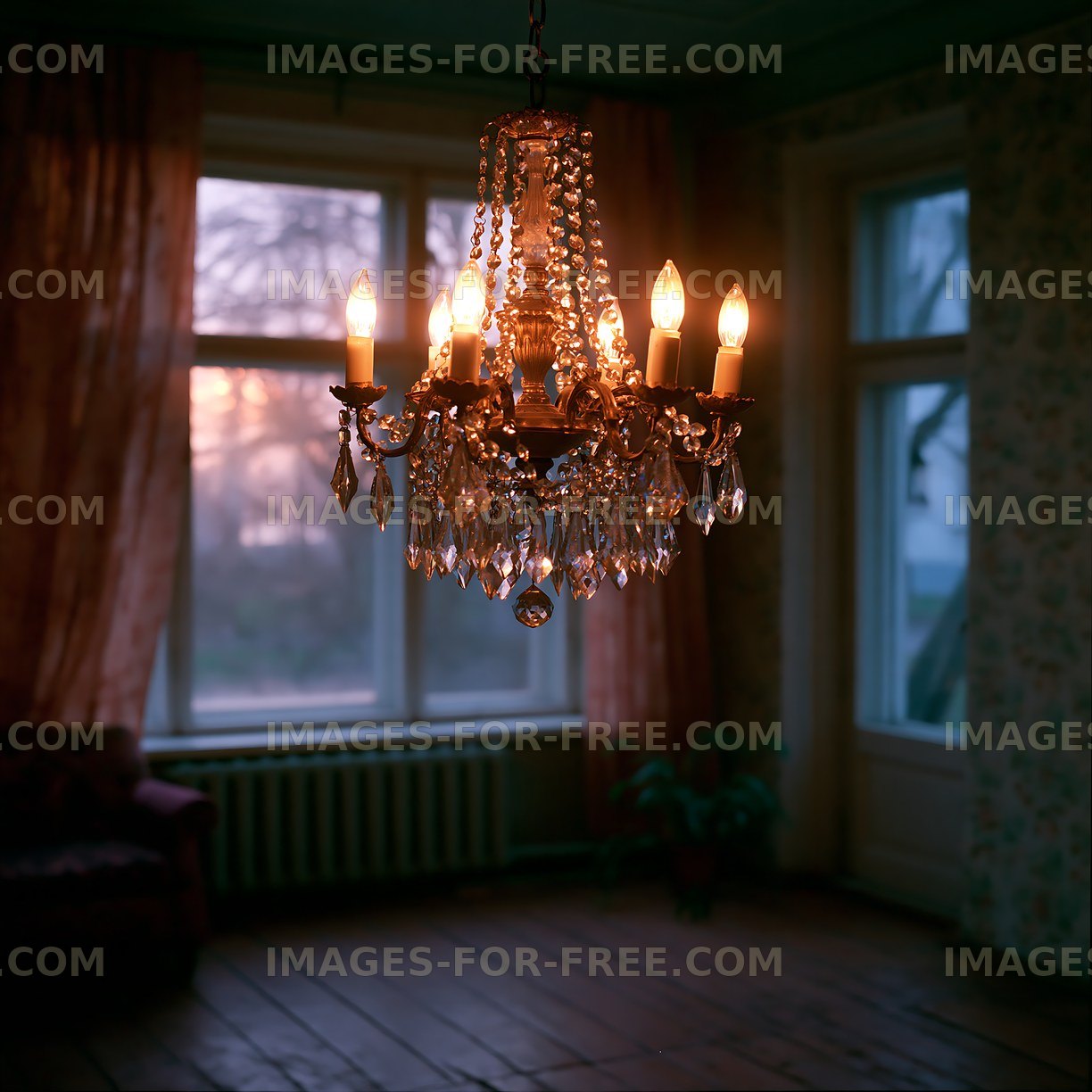 Chandelier hanging in a dimly lit room with a sunset view