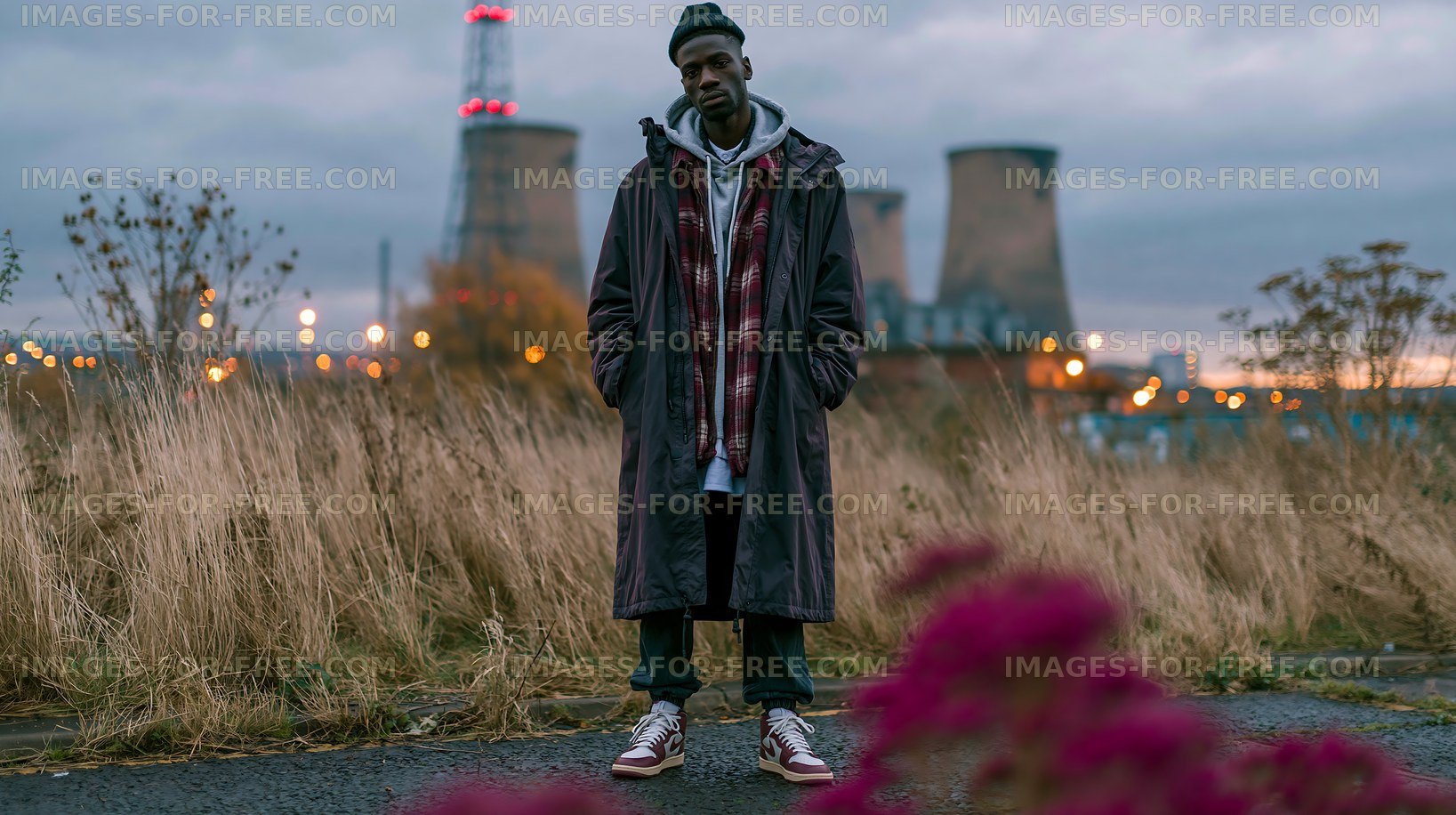 Man standing in an industrial area with power plant in the background