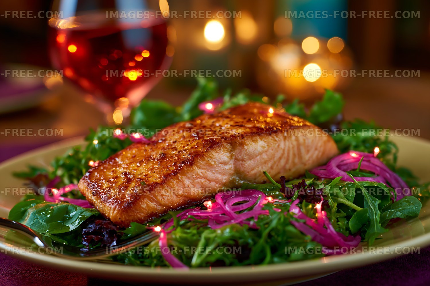 Freshly cooked salmon served on a bed of greens with pink onions