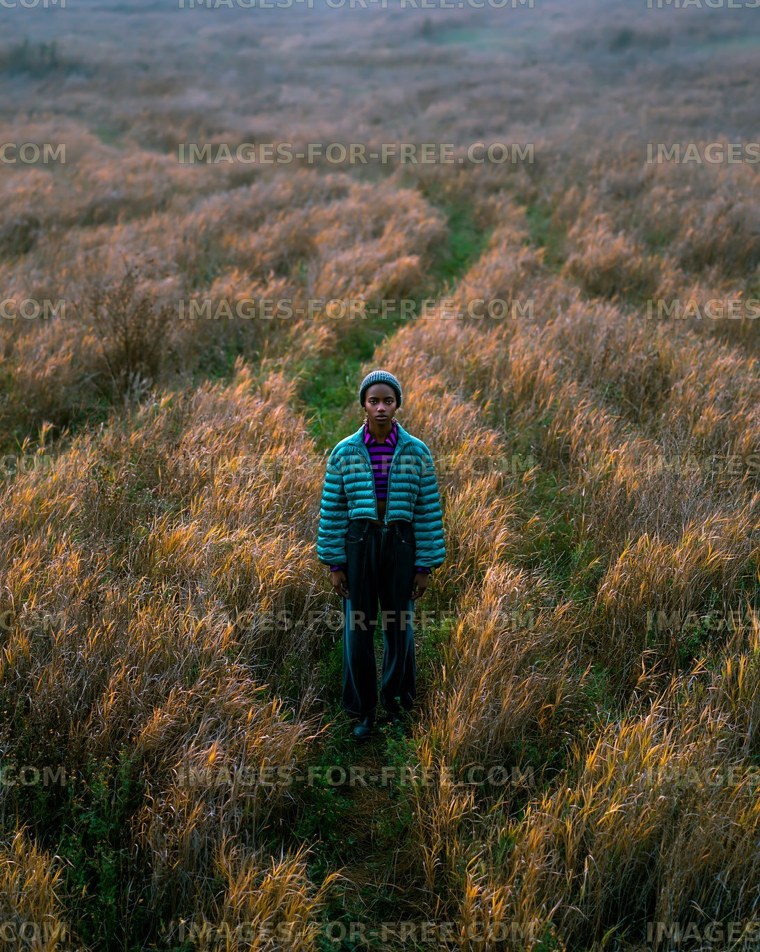 Person standing in a field with tall grass during daytime