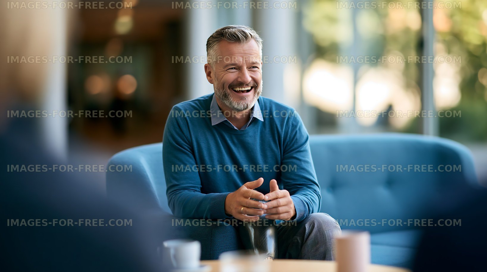 Man laughs during discussion in a modern office setting