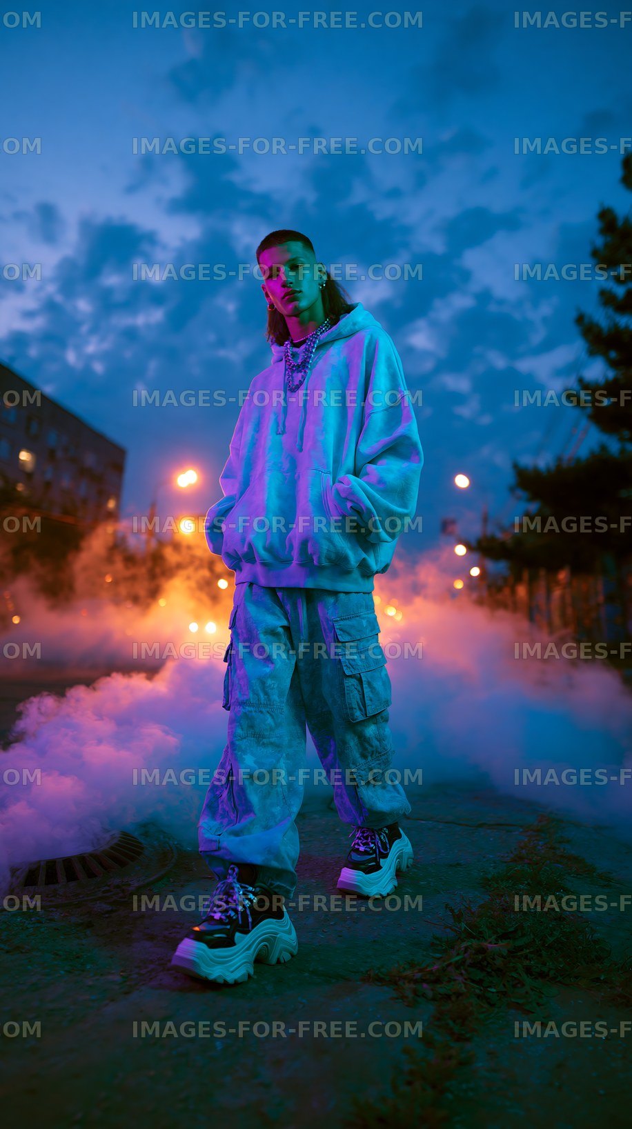 Person standing on street surrounded by fog at dusk