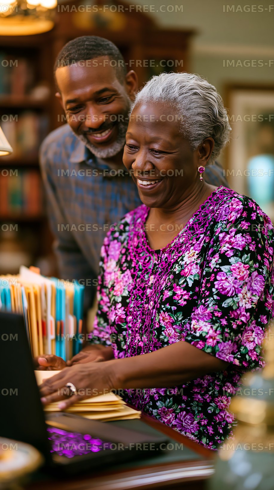 Couple sharing joyful moment while working on a laptop at home