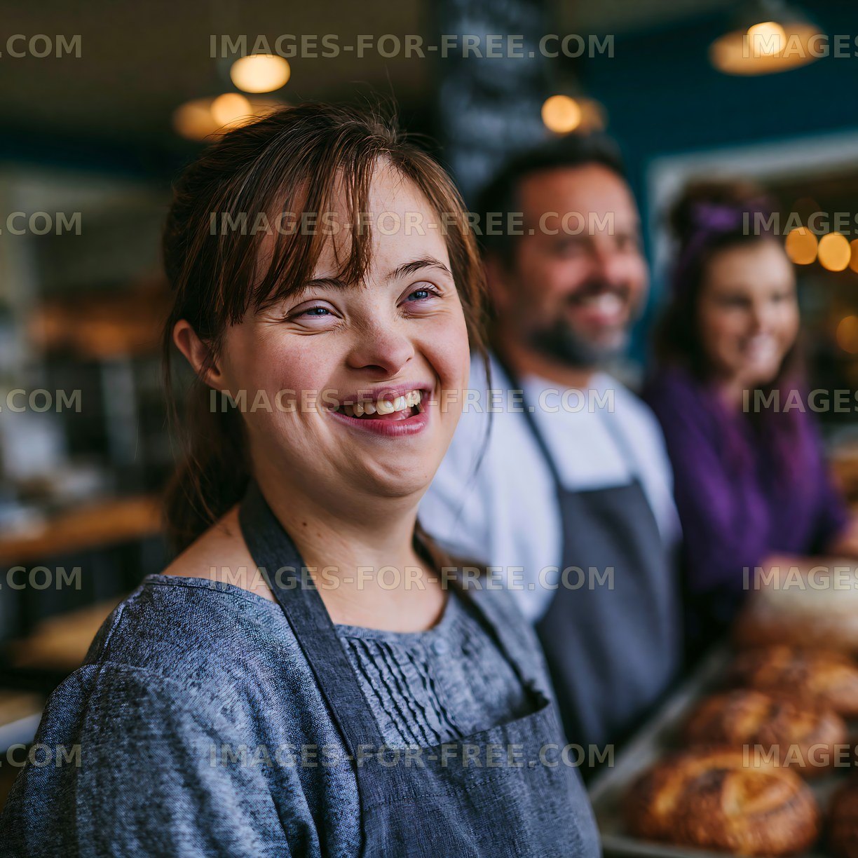 Smiling woman in bakery with coworkers and freshly baked goods