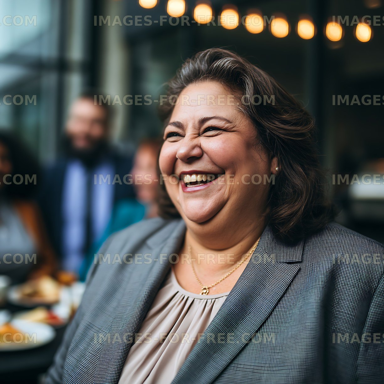 Smiling woman in a gray suit at a social gathering