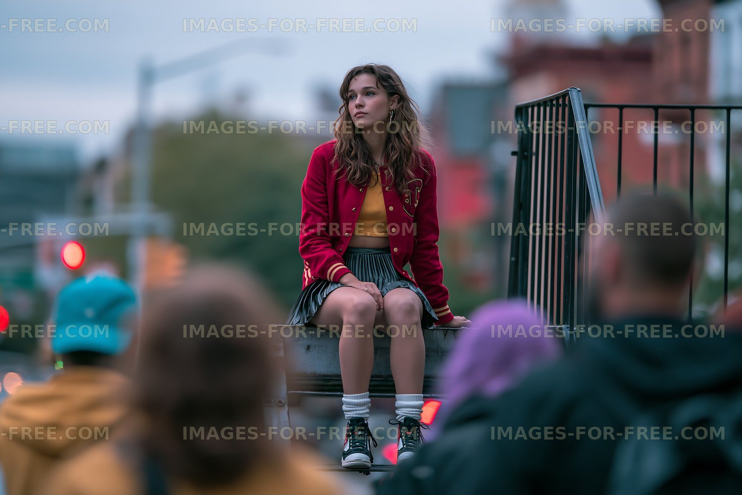 Girl sitting on railing in urban setting with blurred crowd below