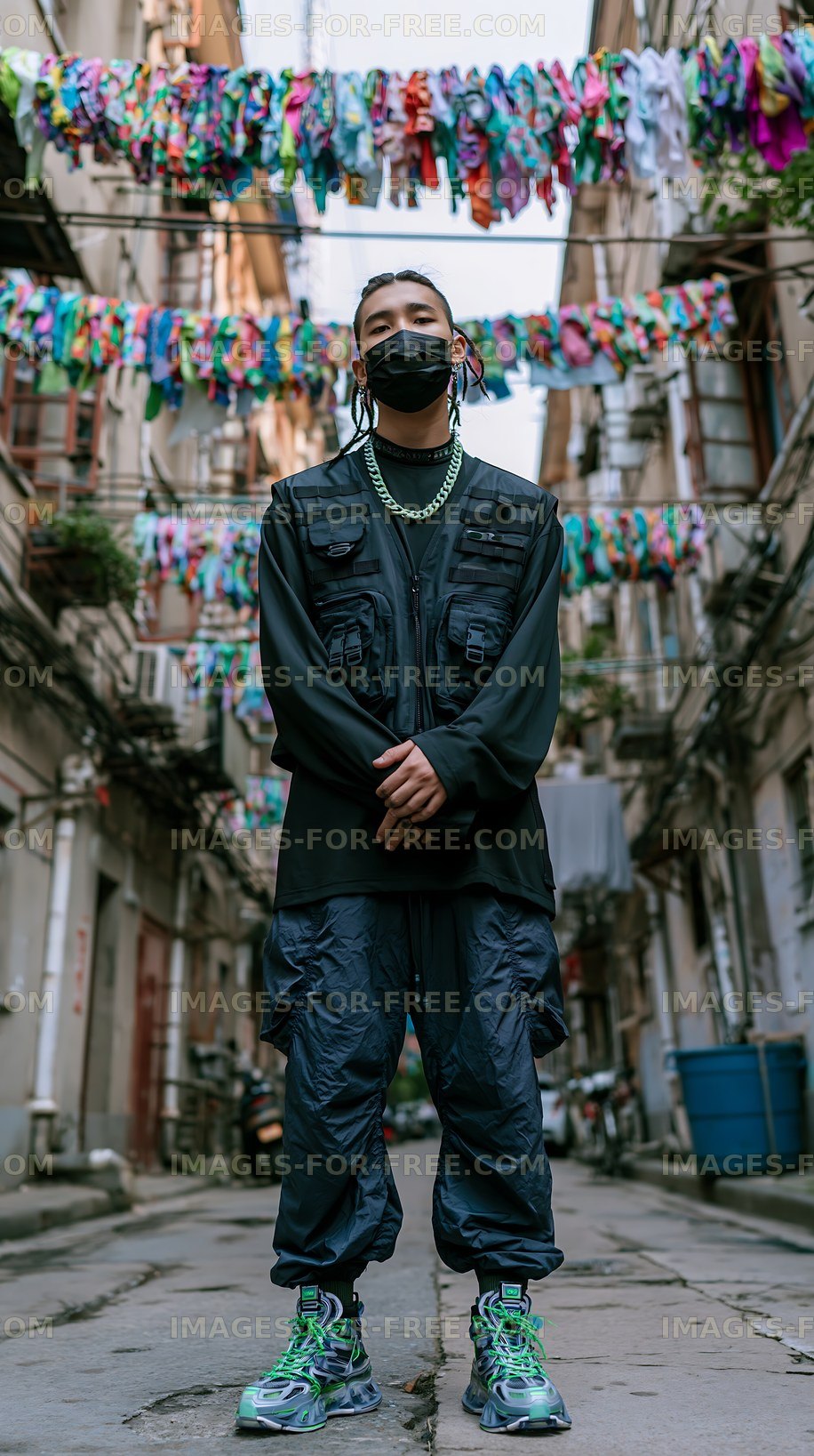 Person stands in a narrow street with colorful clothes hanging above