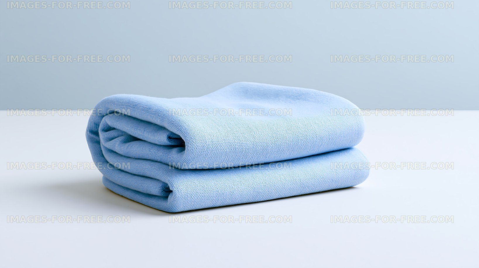 Soft blue towel neatly folded on a light surface