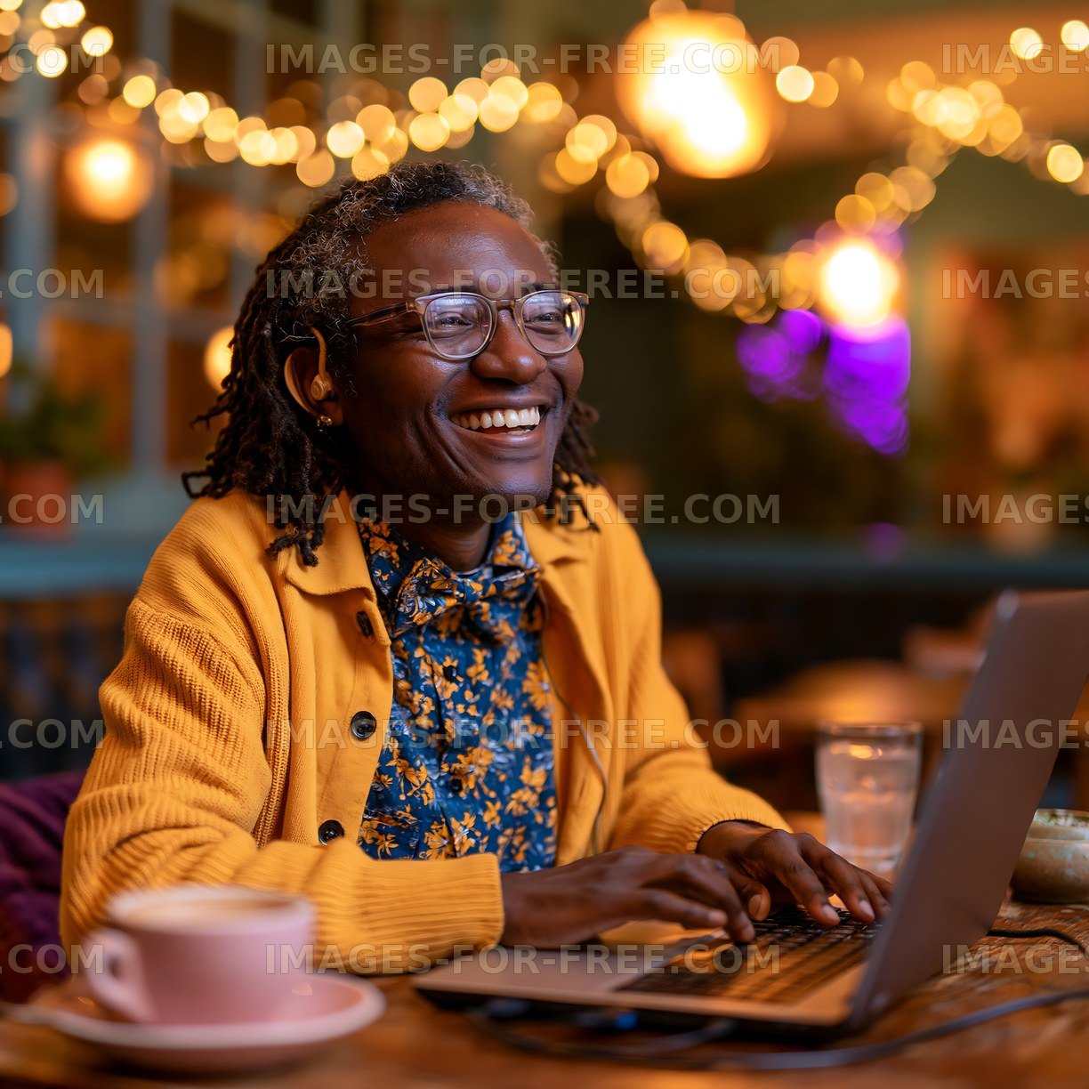 Smiling person working on laptop in cozy cafe with warm lighting