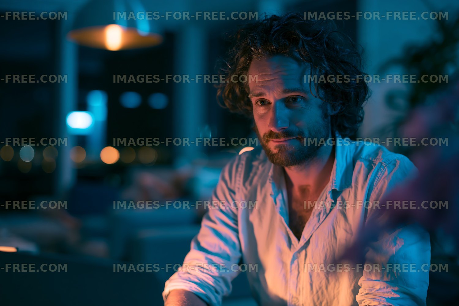 Man sitting and looking thoughtfully in a dimly lit room