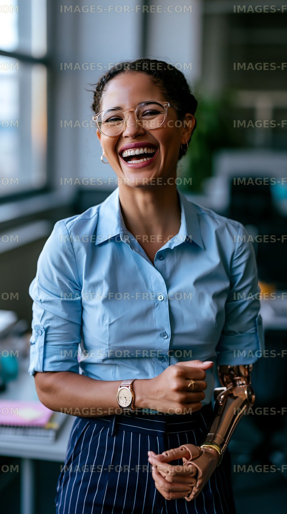 Woman smiles while working in modern office with a prosthetic arm