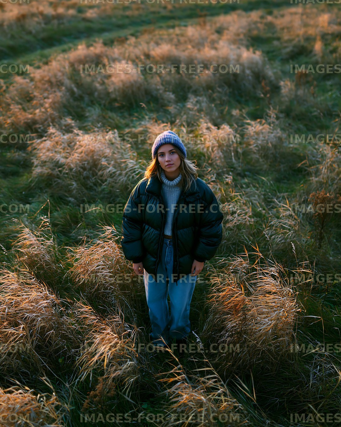 Woman standing in a field of grass during sunset