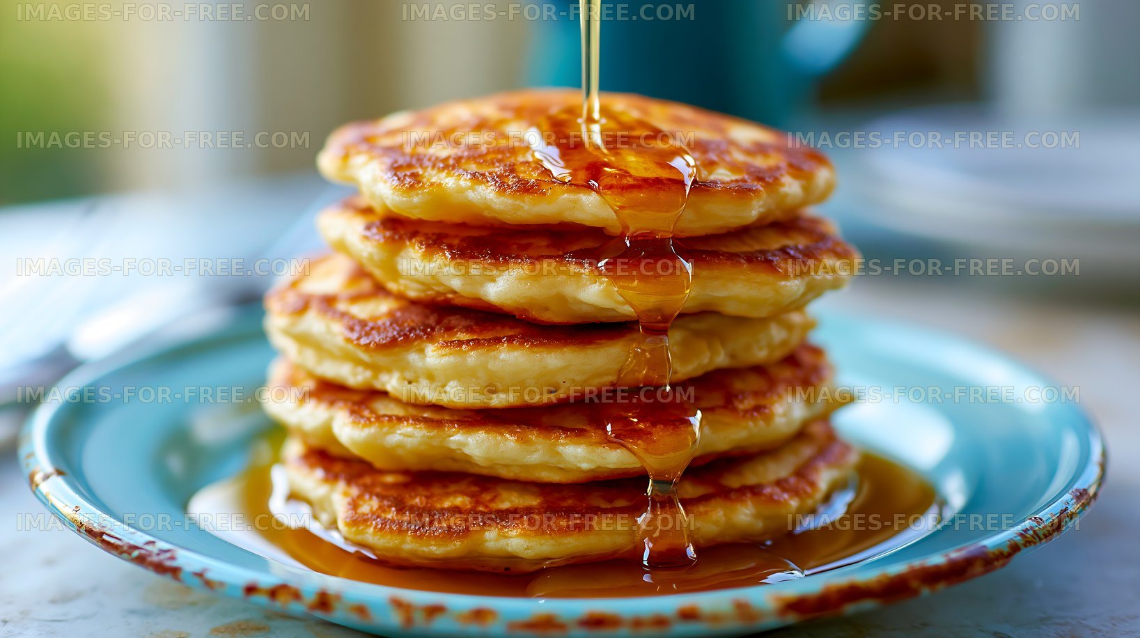 Pancakes stacked on a blue plate with syrup pouring on top