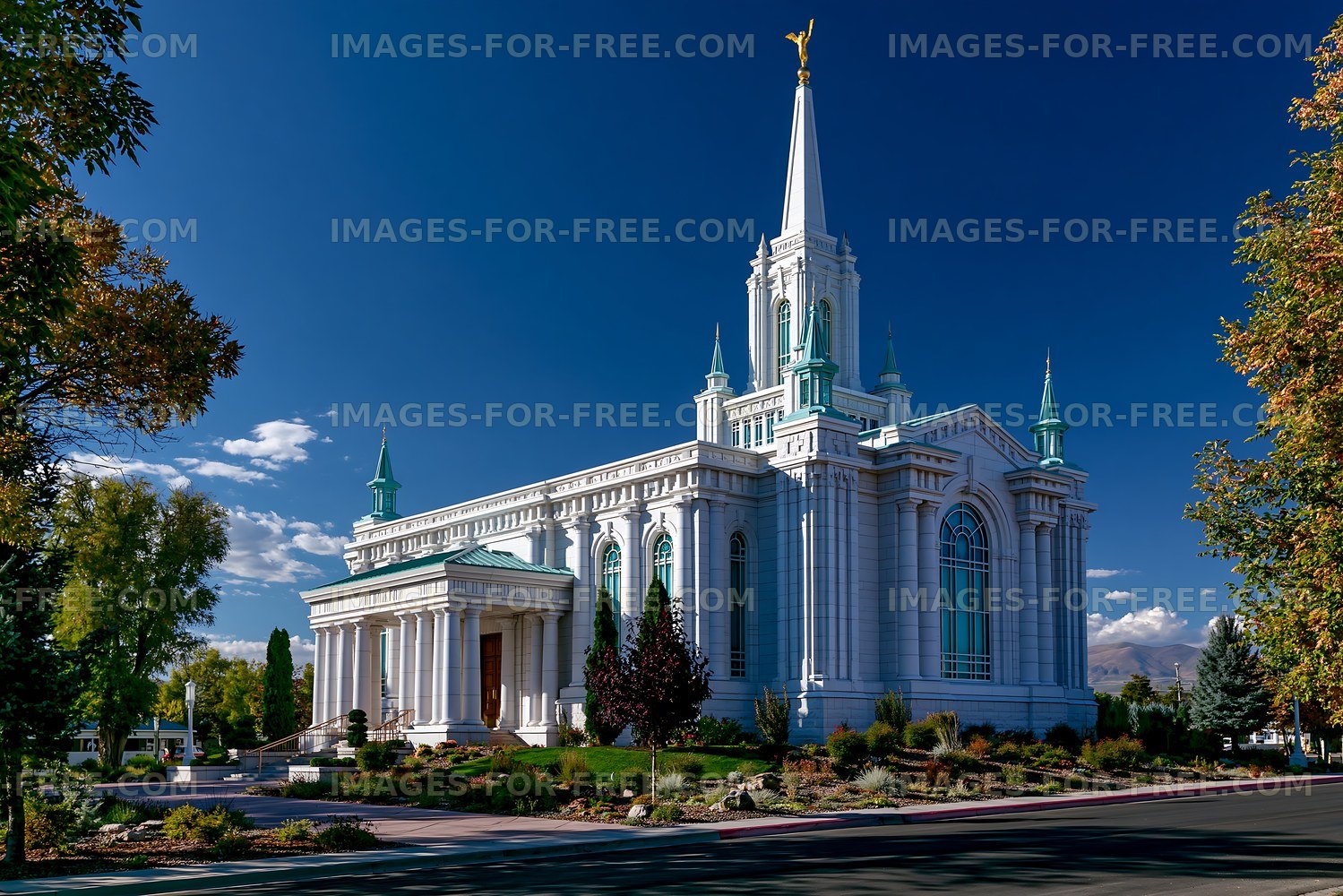 White modern church building with spire against blue sky