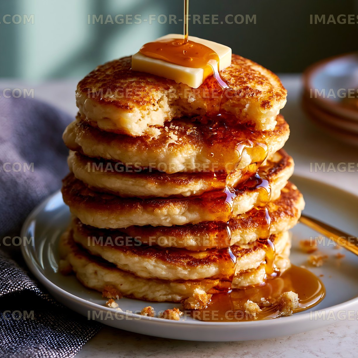 Stack of pancakes with syrup and butter on a plate