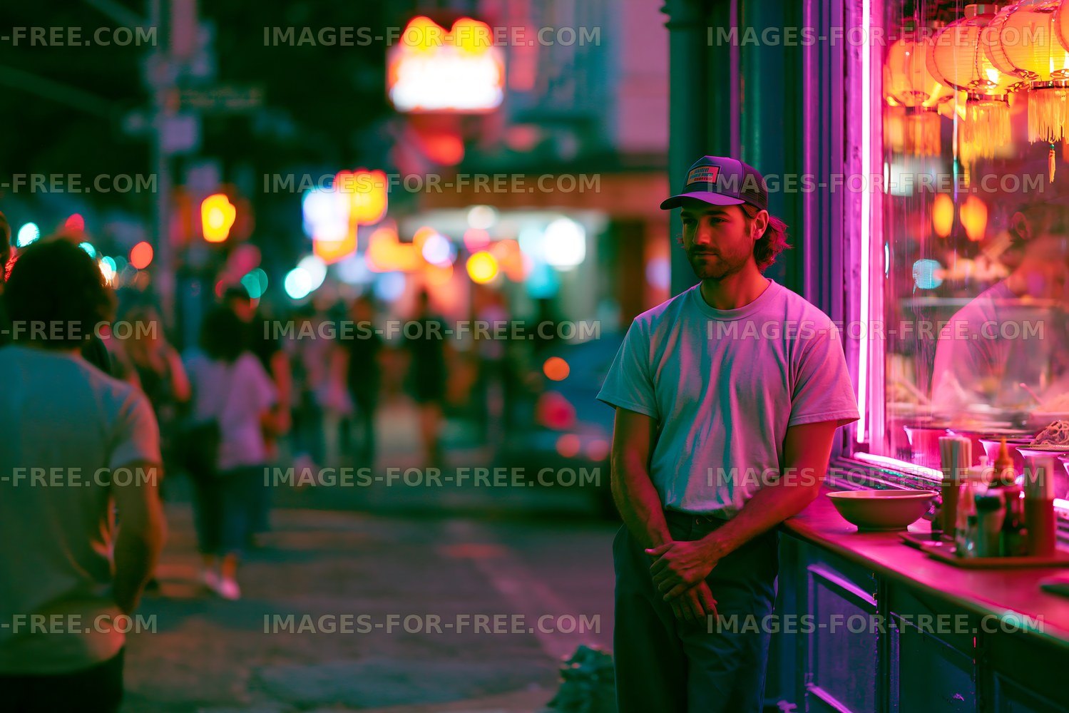 Man standing by restaurant window at night with colorful lights
