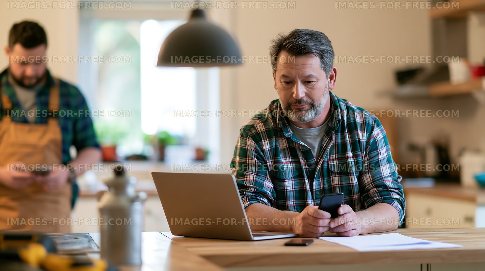 Men using devices in a kitchen workspace