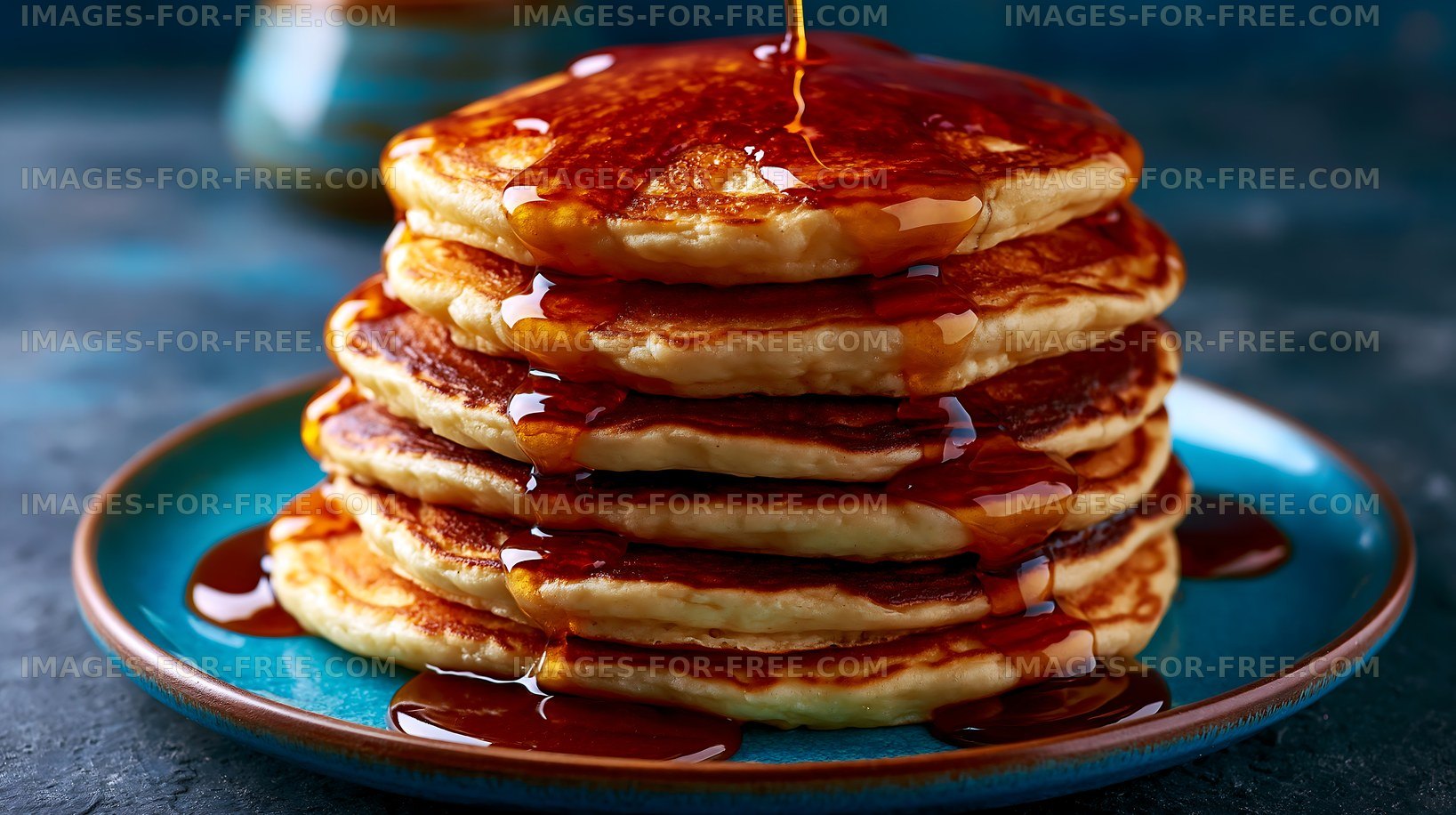 Stack of pancakes with syrup on a blue plate