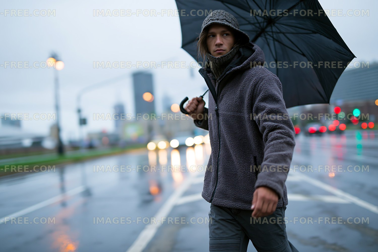 Man walking on wet street holding umbrella in rainy weather