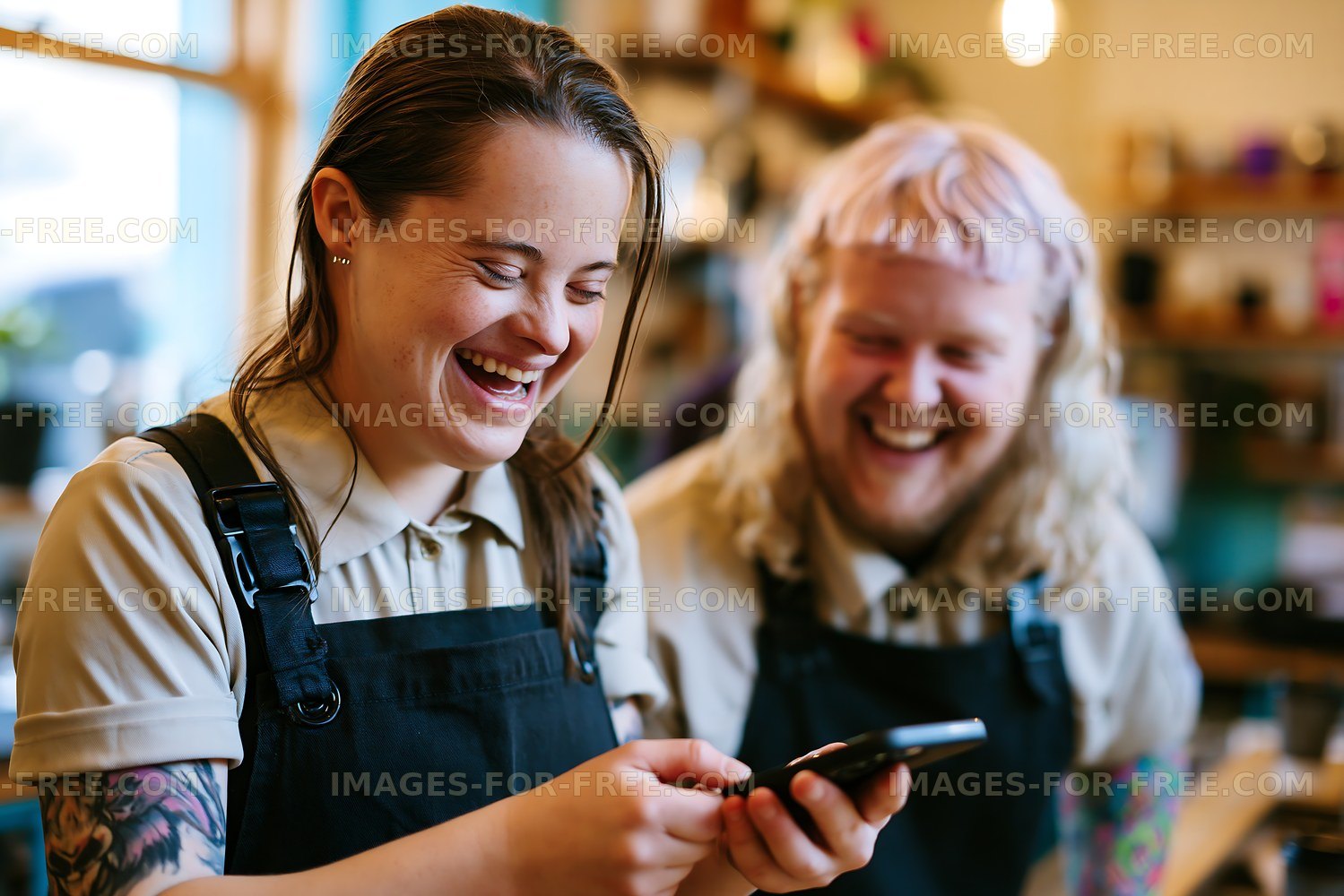 People laughing while using a smartphone in a cafe setting