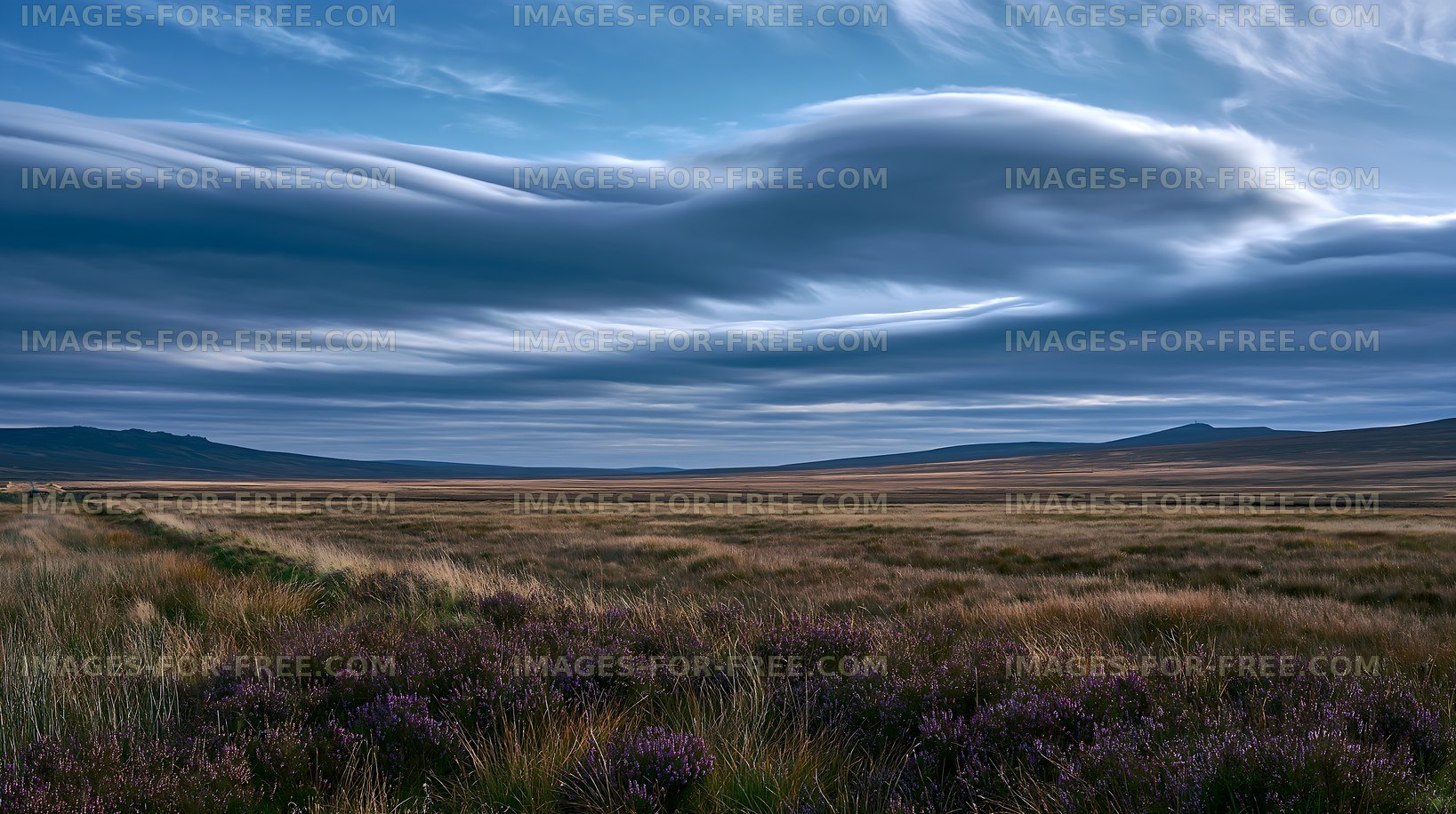 Wide open landscape with clouds above hills and fields