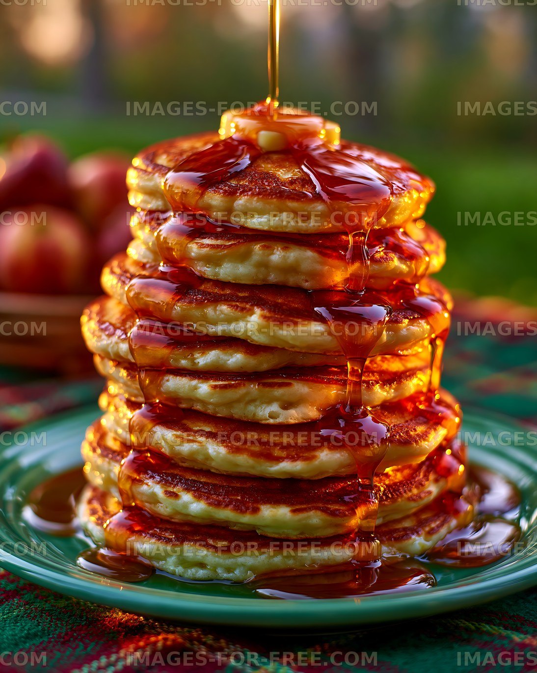 Stack of pancakes with syrup and butter served outdoors