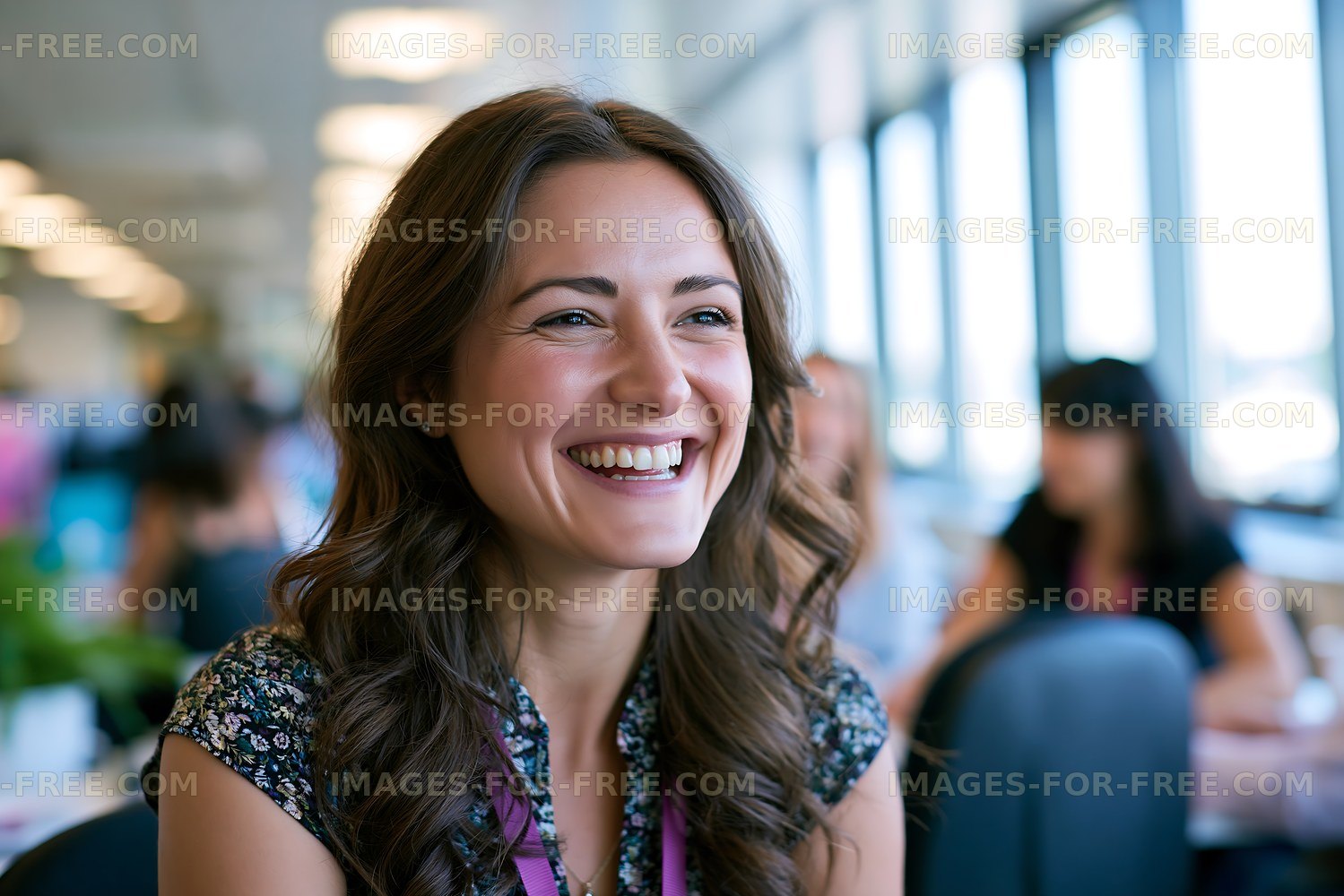Woman smiling in a casual indoor setting with people around her